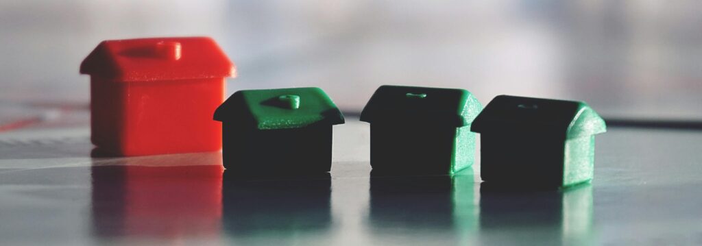 Plastic miniature houses in green and red, symbolizing real estate assets in estate planning