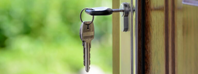 Key in a door lock, symbolizing real estate ownership and property transactions